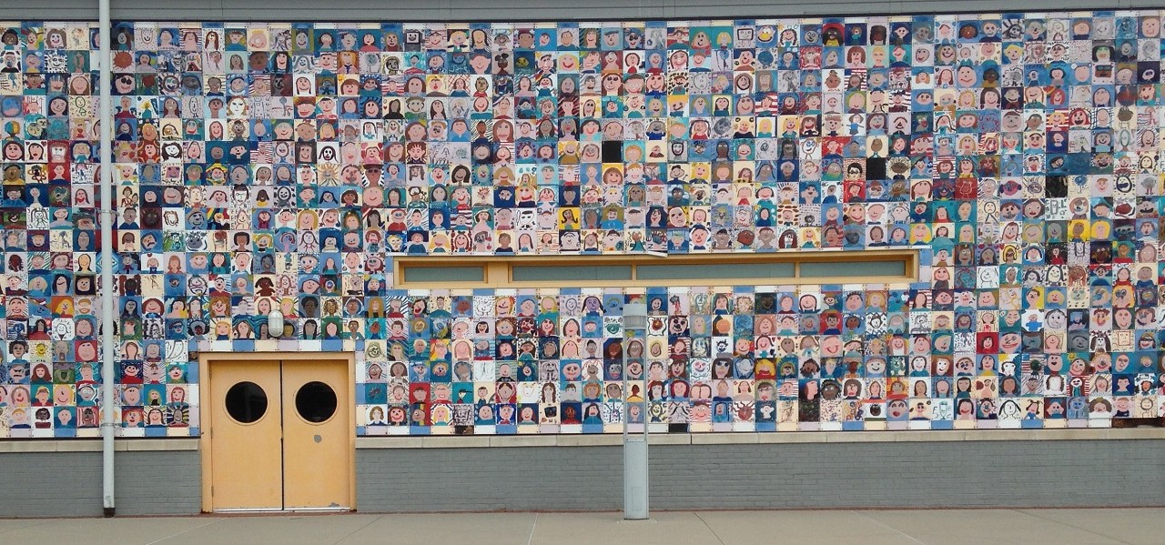 View of an exterior wall with self-portraits covering it.
