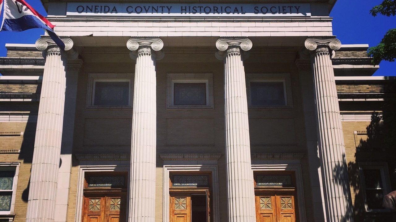 Exterior view of a Greek classical style structure with a columned entrance.