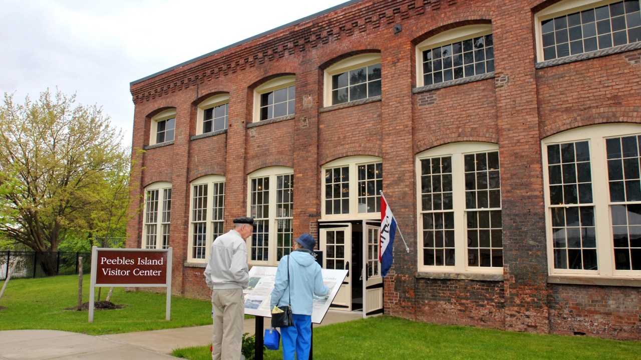Exterior image of a red brick building with large windows on the ground floor and smaller windows above.