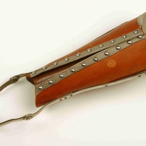 Leather contraption with metal trim and an ankle strap.