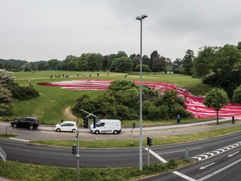 View of the exterior of the museum grounds with a road and the art installation crossing the road.