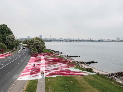 View of the exterior of the museum grounds with a road and the art installation crossing the road.
