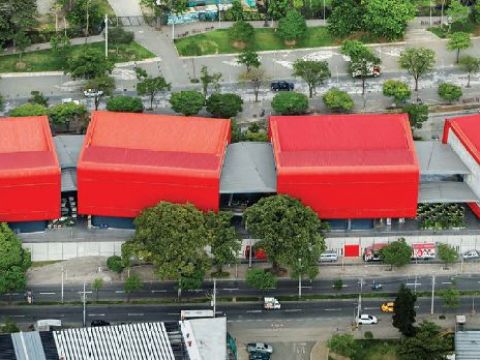 Four rectangular structures connected by gray passthroughs with red roofs sit in a stark landscape.