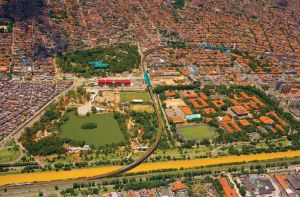 Fly over shot of Medellín with the Parque Explora a small red area center left.