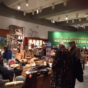 Interior view of the Carnegie Museum of Natural History's Museum store with a few people shopping. 