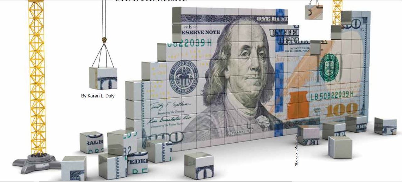 A $100 dollar bill stands at an angle made up of blocks with construction equipment placing the blocks on either end.