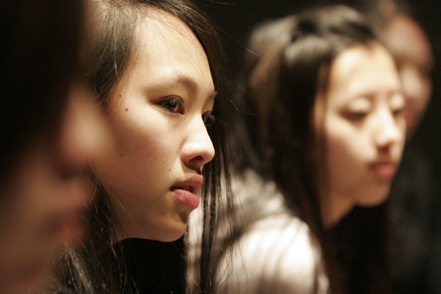 Two young women are shown listening to group discussion about the concept and experience of race, in an example of the Science Museum of Minnesota's efforts toward diversity, equity, and inclusion.