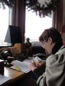 Francesca Tronetti Ph.D., author of the post, sits at a desk in period costume in front of the exhibit she designed on telegraphy.