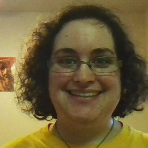 Headshot/selfie of Samantha Silverberg smiling at the camera with short brown hair wearing wire rimmed glasses.