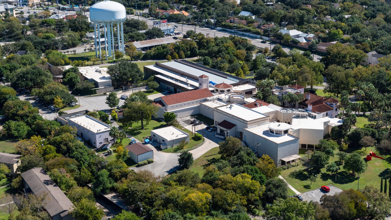 Areal view of the McNay Museum buildings with a water tower in the top left distance.
