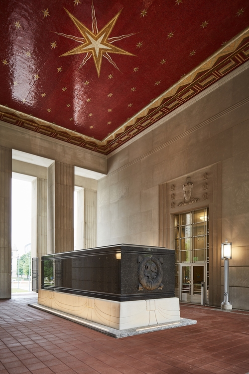 A black marble cenotaph on a pedestal inside the entryway of Soldiers Memorial, with strong lighting for improved visibility.