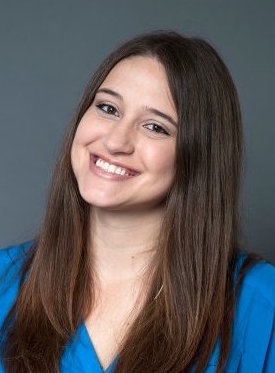 Headshot of Stacey Ingram Kaleh, a white woman with long dark brown hair smiling at the camera wearing a blue blouse.