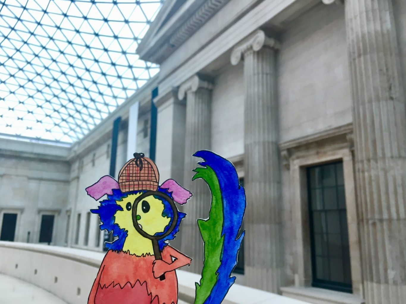 Marabou is posed inside of the British Museum in front of columns and under the glass ceiling. They hold a magnifying glass and wear a detective hat.