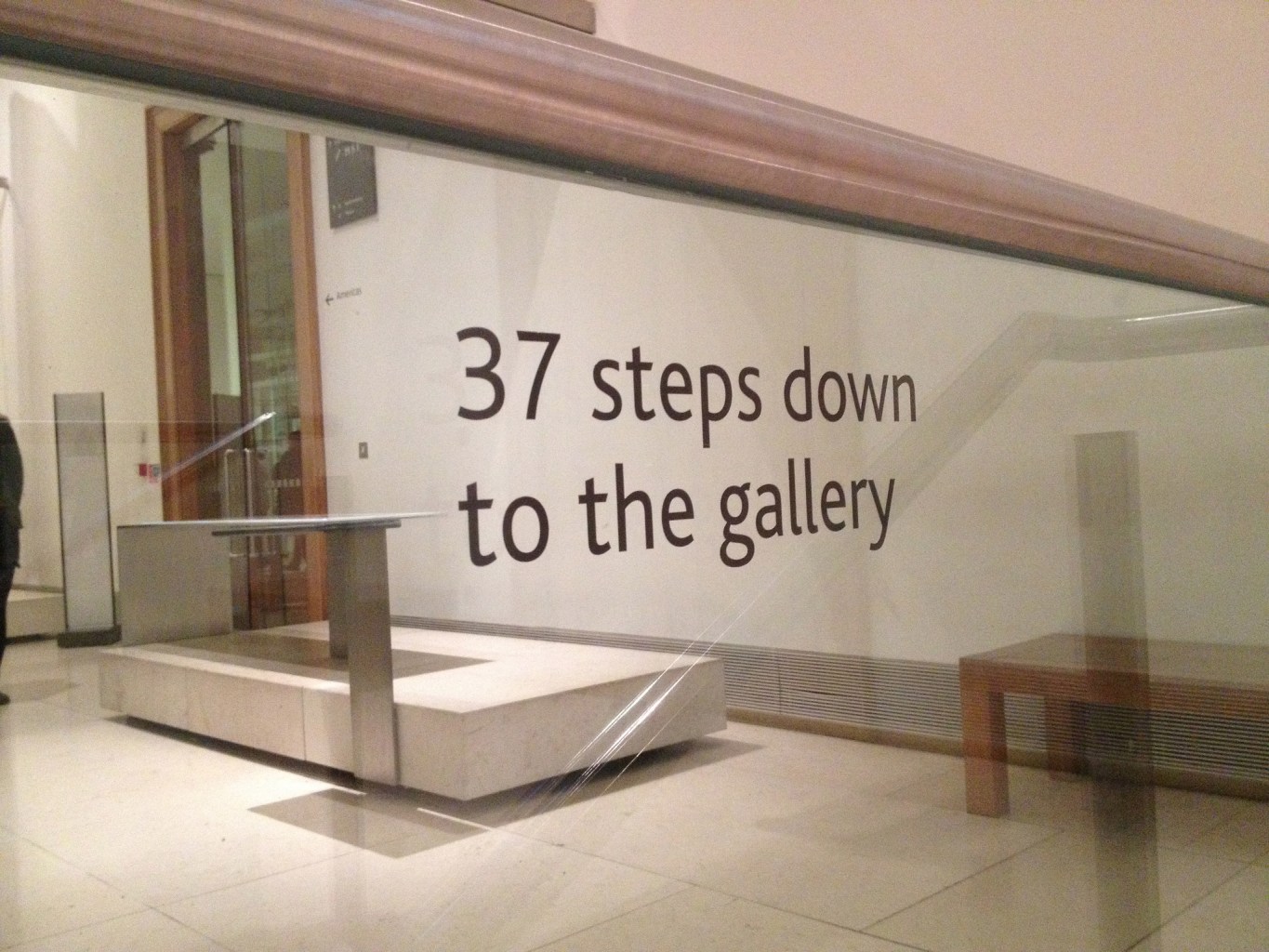 At the top of a staircase in a museum, a sign advises that there are "37 steps down to the gallery."