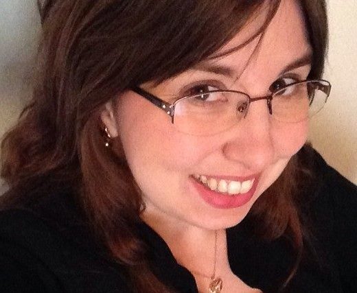 Headshot of Tiffany Rhoades Isselhardt, a white woman with long dark brown hair wearing light rimmed glasses.