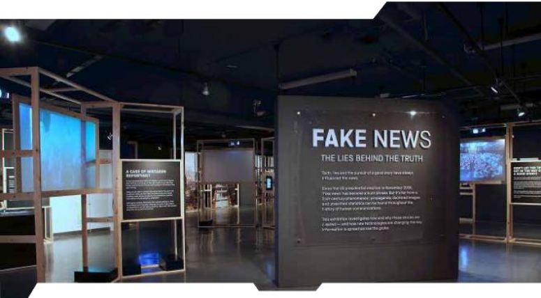 Image of the interior of a very darkly painted exhibition on Fake News. 