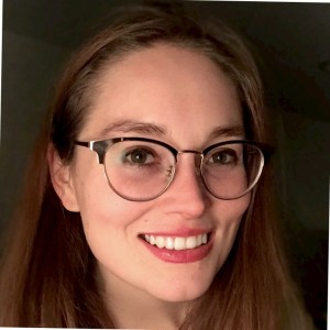 Headshot of Carissa Pfeiffer, a white woman with long reddish brown hair wearing metal rimmed glasses.