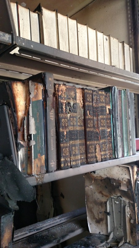 A shelf of burned, charred books.