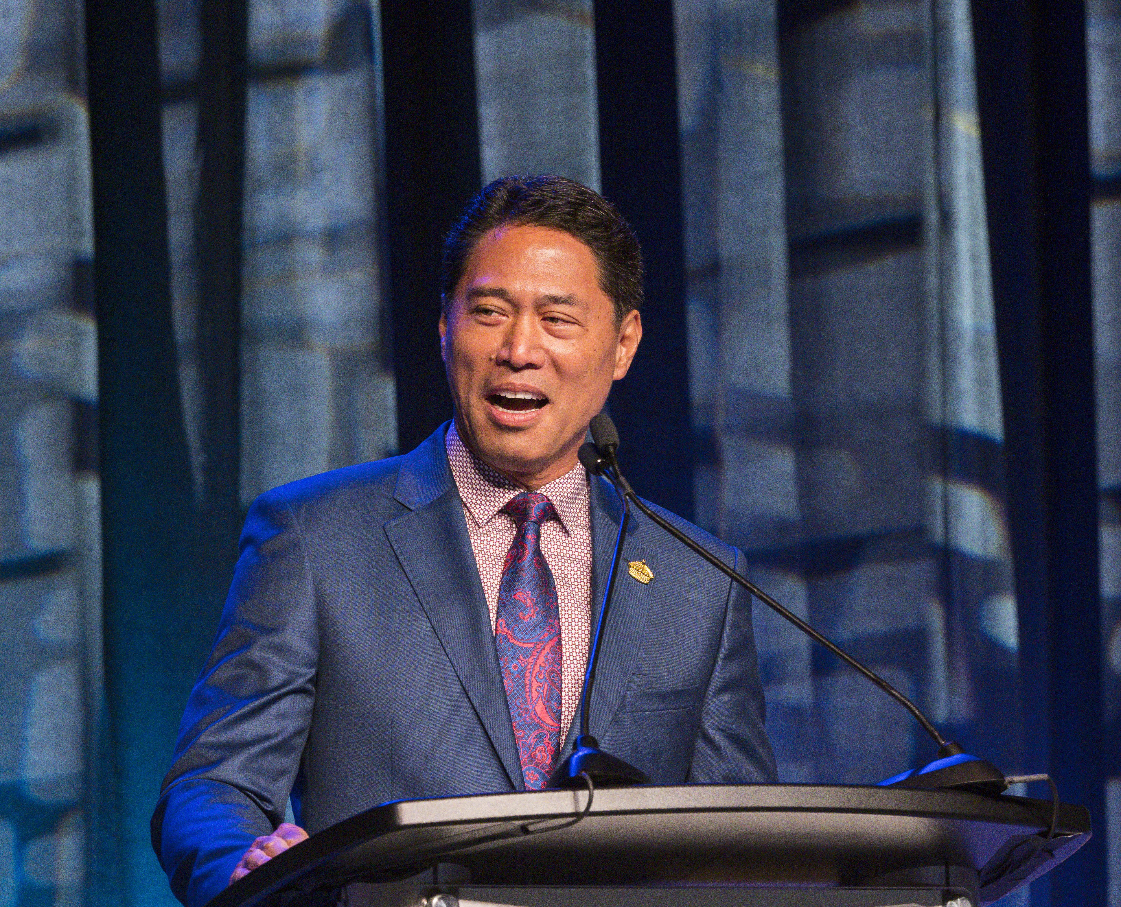 Kippen de Alba Chu speaks at a podium.