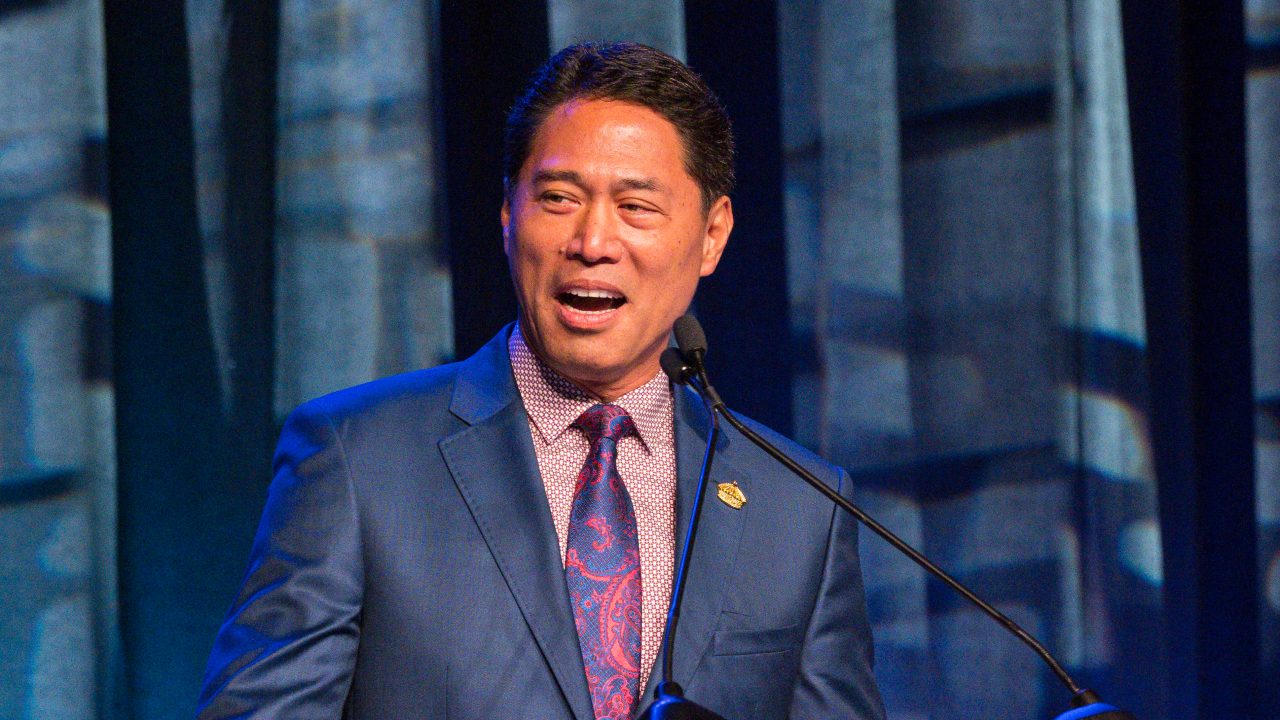 Kippen de Alba Chu speaks at a podium.