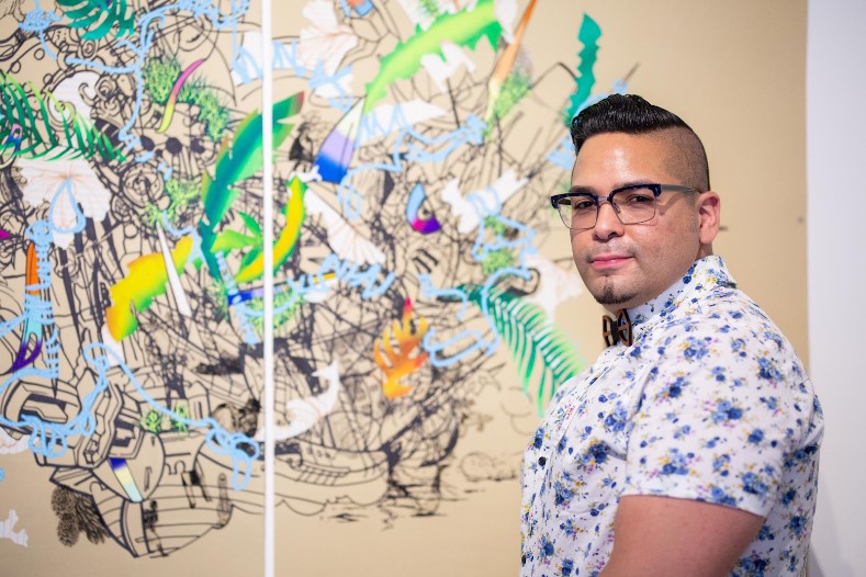 David Rios in front of a graphic print. 