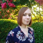 Headshot of Anna Woten standing outside in front of a flowering tree.