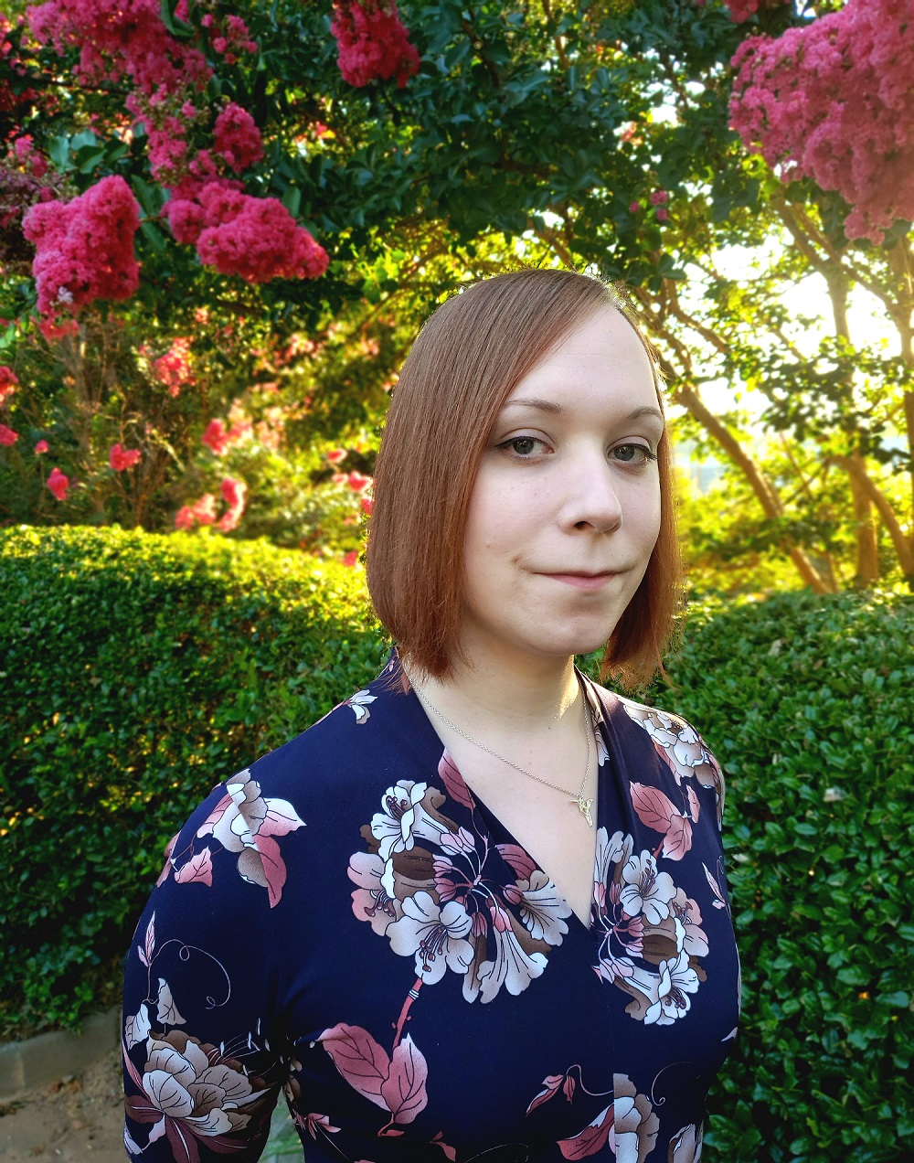 Headshot of Anna Woten standing outside in front of a flowering tree.