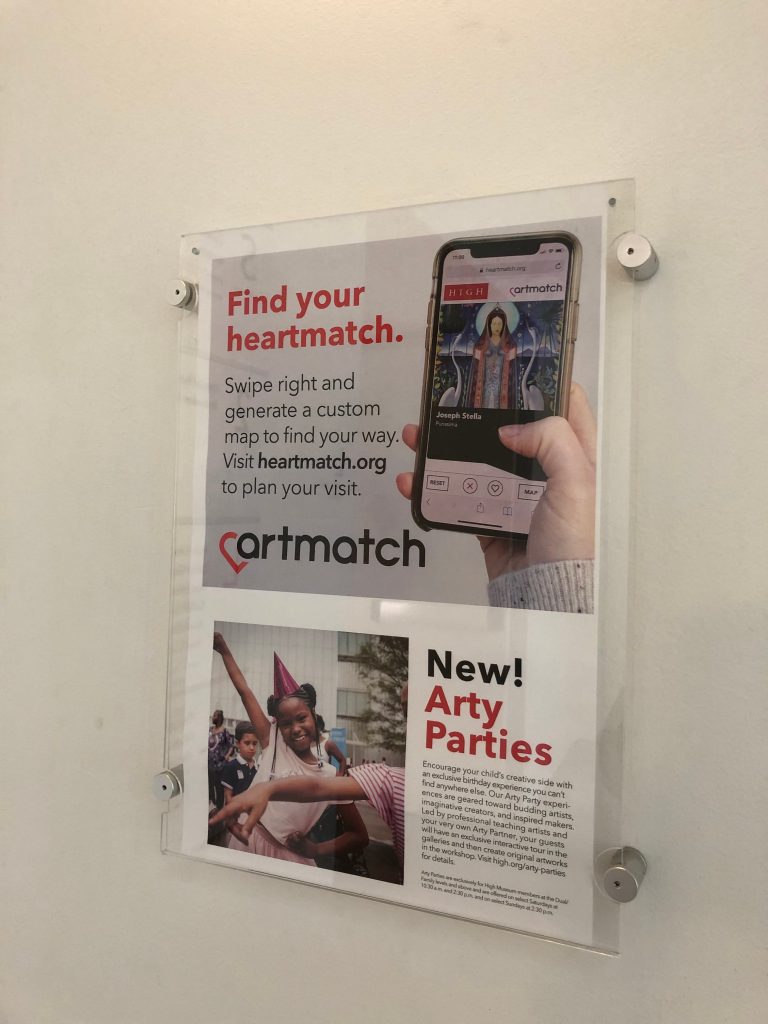 An ad hung on a wall says "Find your heartmatch. Swipe right and generate a custom map to find your way. Visit heartmatch.org to plan your visit."