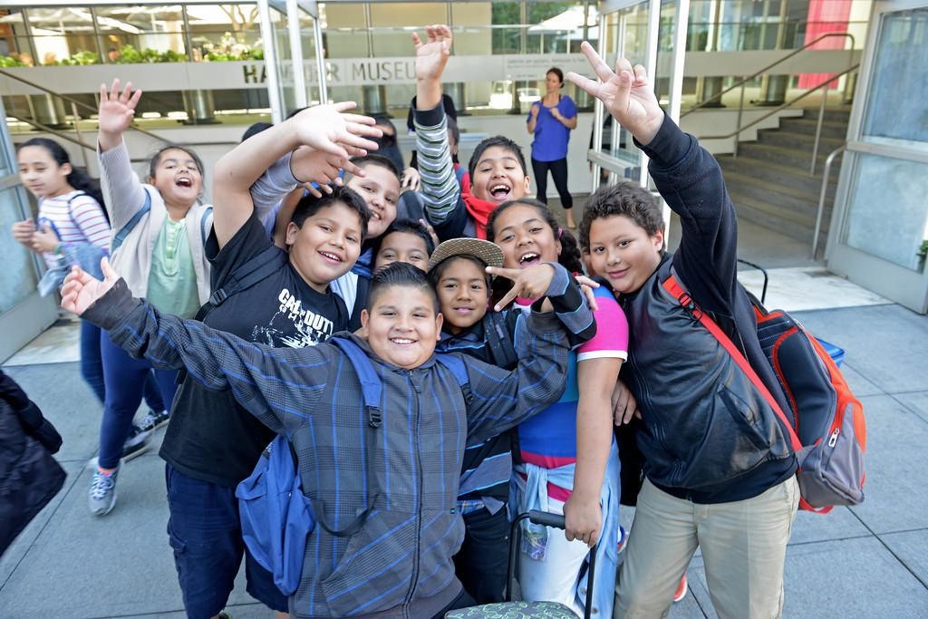 A group of exuberant students poses outside the front door of the museum, where they appear to be leaving.