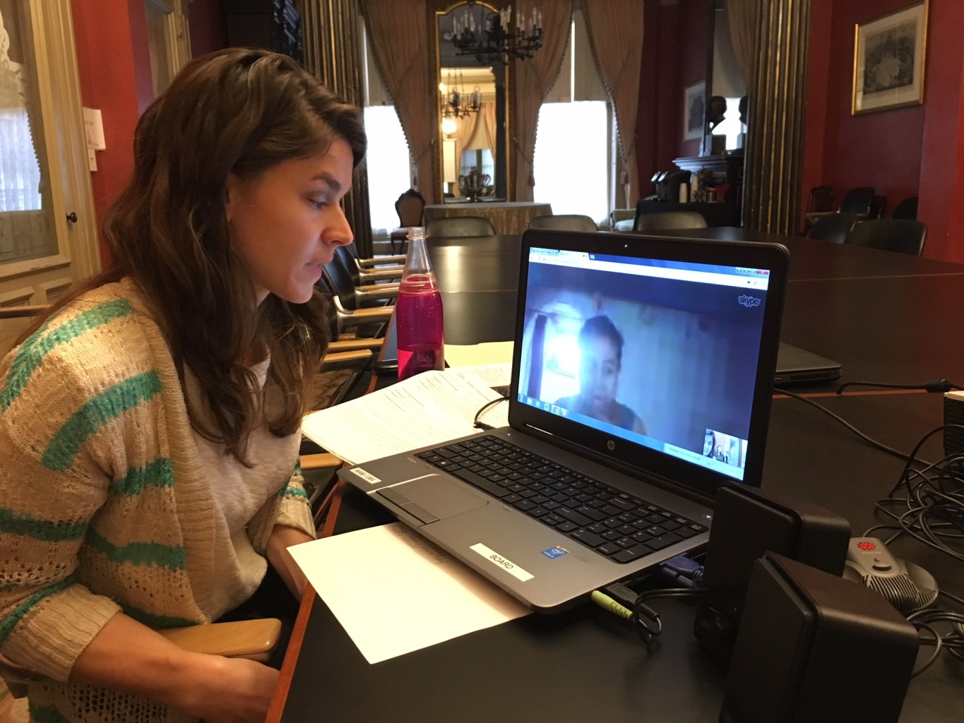 Susan sits in front of a laptop where Tsiroy is visible on a video chat screen.