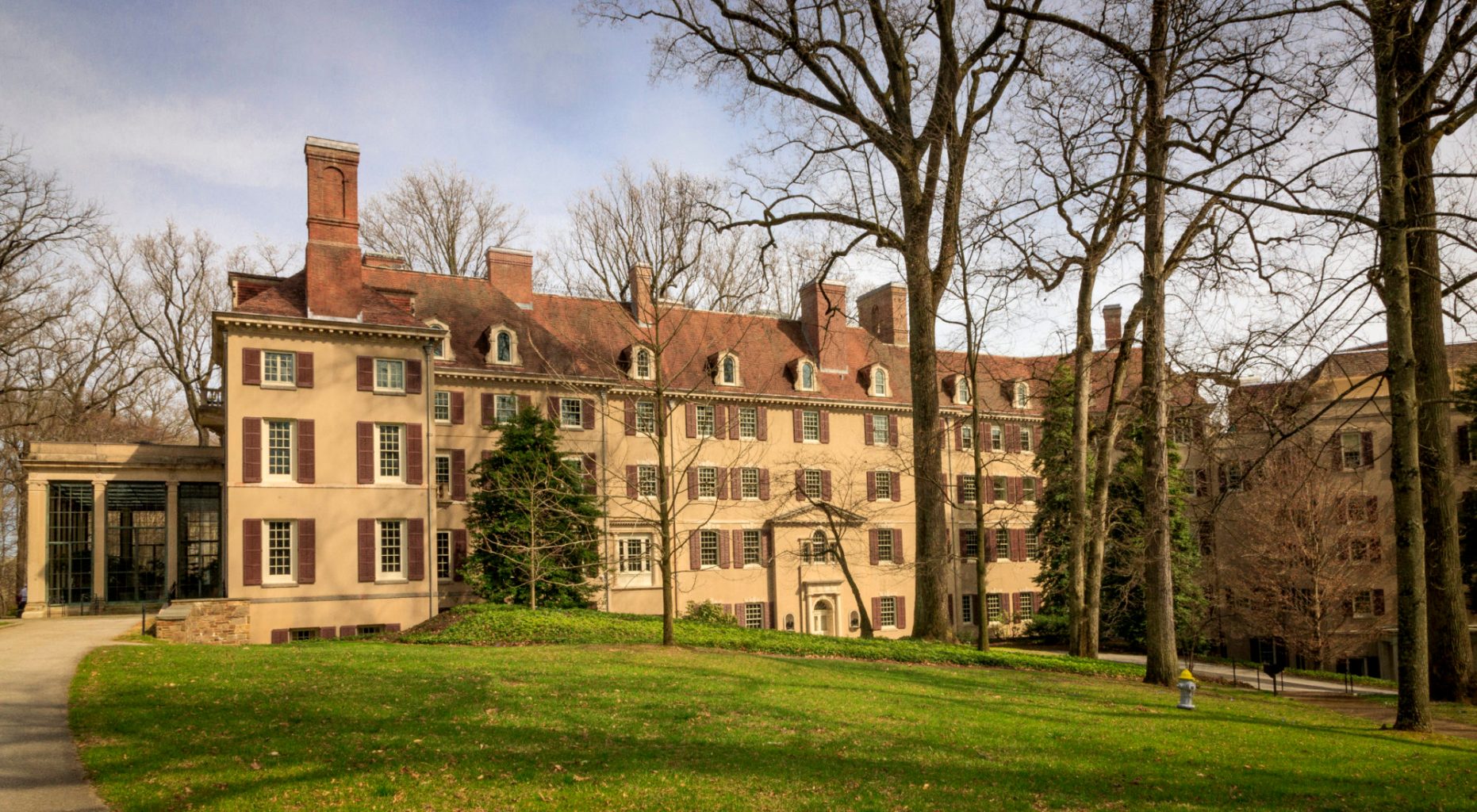 Exterior of a large estate on sprawling, manicured grounds.