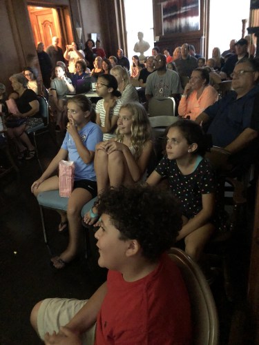 Campers and guests in a screening room watching the films