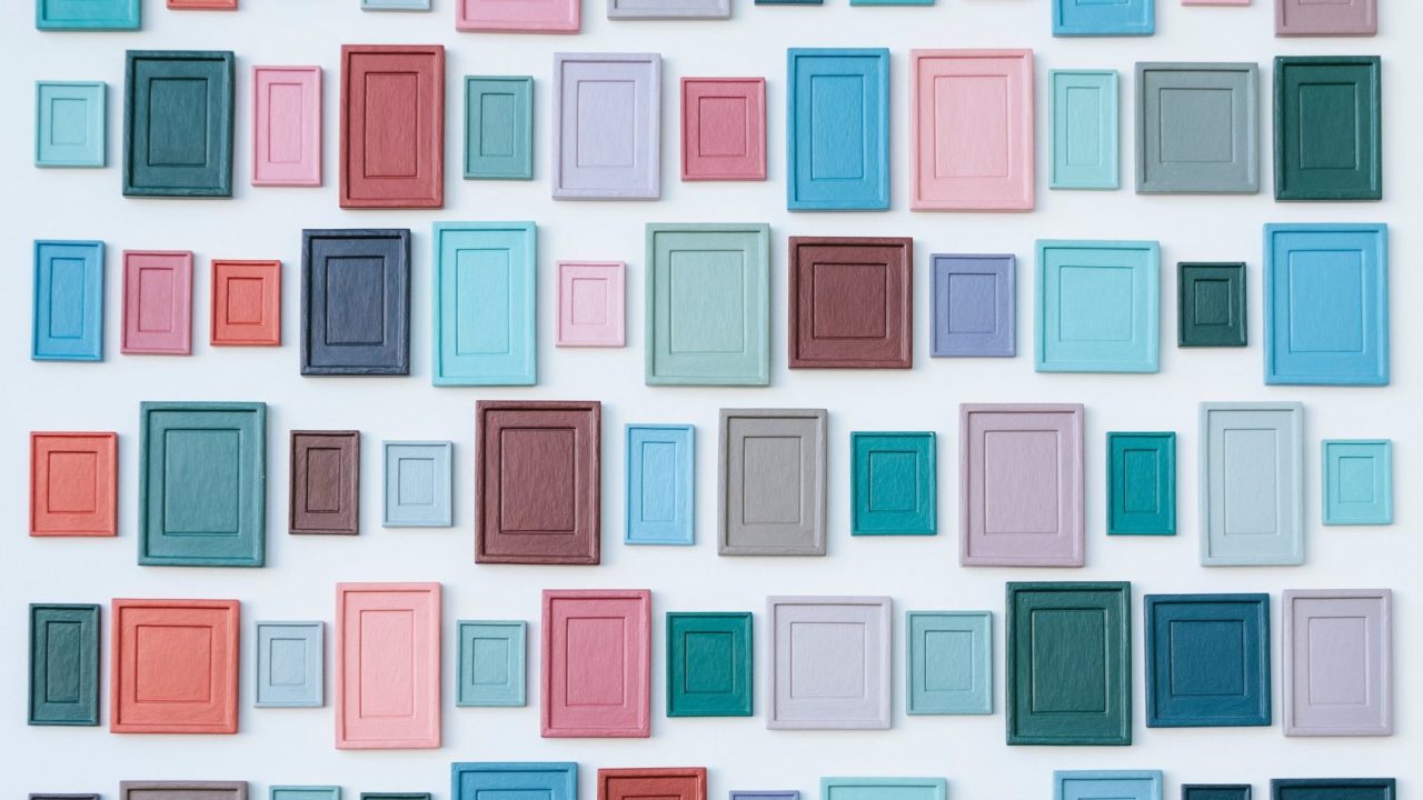 A wall of empty frames in a variety of sizes and colors.