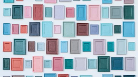 A wall of empty frames in a variety of sizes and colors.