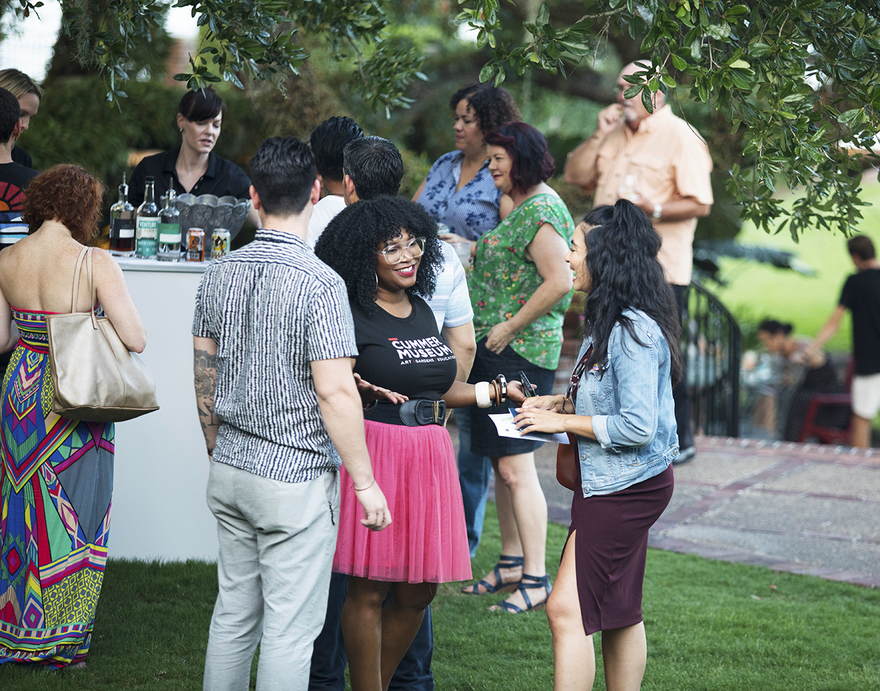 Attendees congregate outside near a bar and engage in conservation.