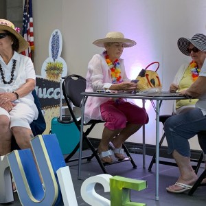 A group of participants on stage sitting at a table in their scene