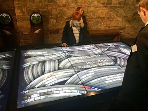 A visitor uses a flat interactive screen with a timeline of events on it.