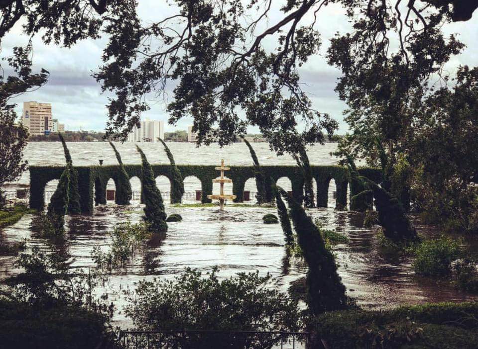 The garden is seen submerged in water, with only a few trees and architectural features visible.