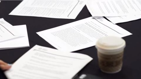 Various papers strewn across a black table clothed table.