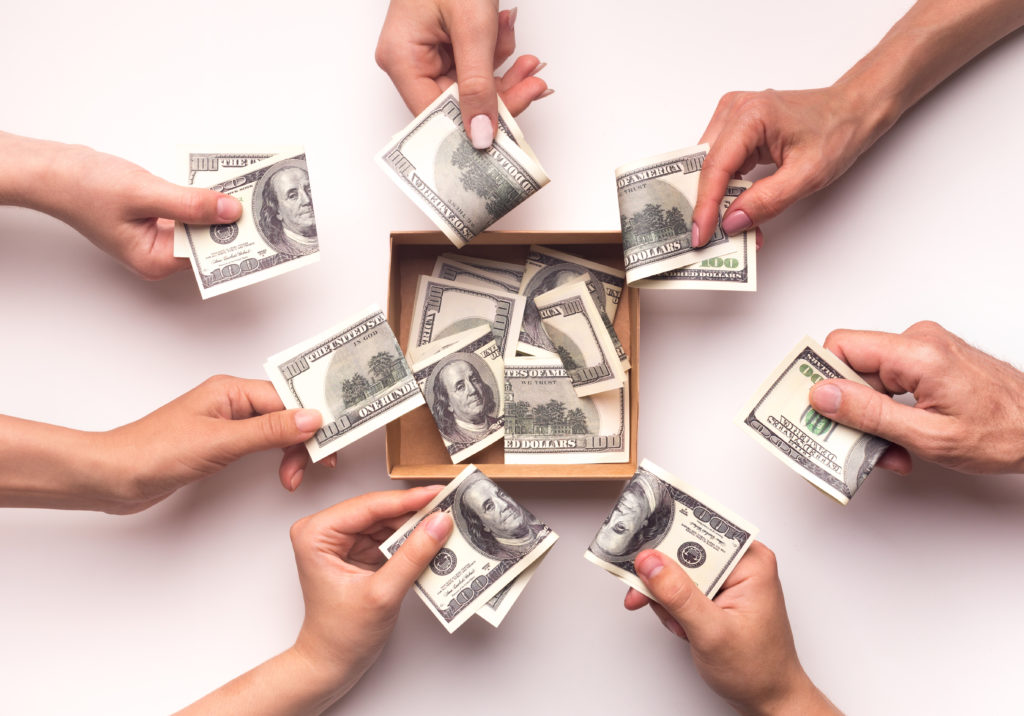 7 hands with hundred dollar bills in them