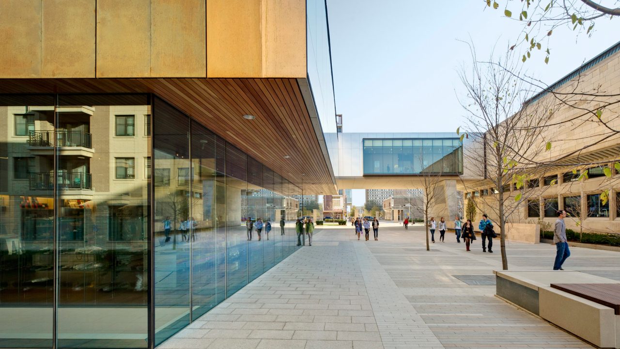 Exterior of a building focused on a walkway, where students are crossing past