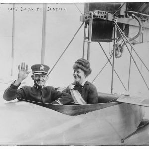 Lucy burns smiling in the cockpit of a small plane.