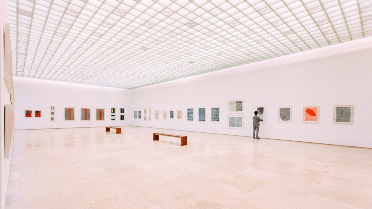Wide shot of a museum gallery with paintings on display