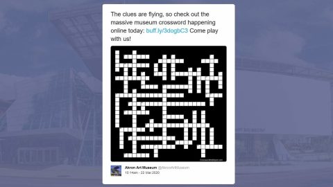 A tweet reading "The clues are flying, so check out the massive museum crossword happening online today...Come play with us!" with an image of an empty crossword puzzle.