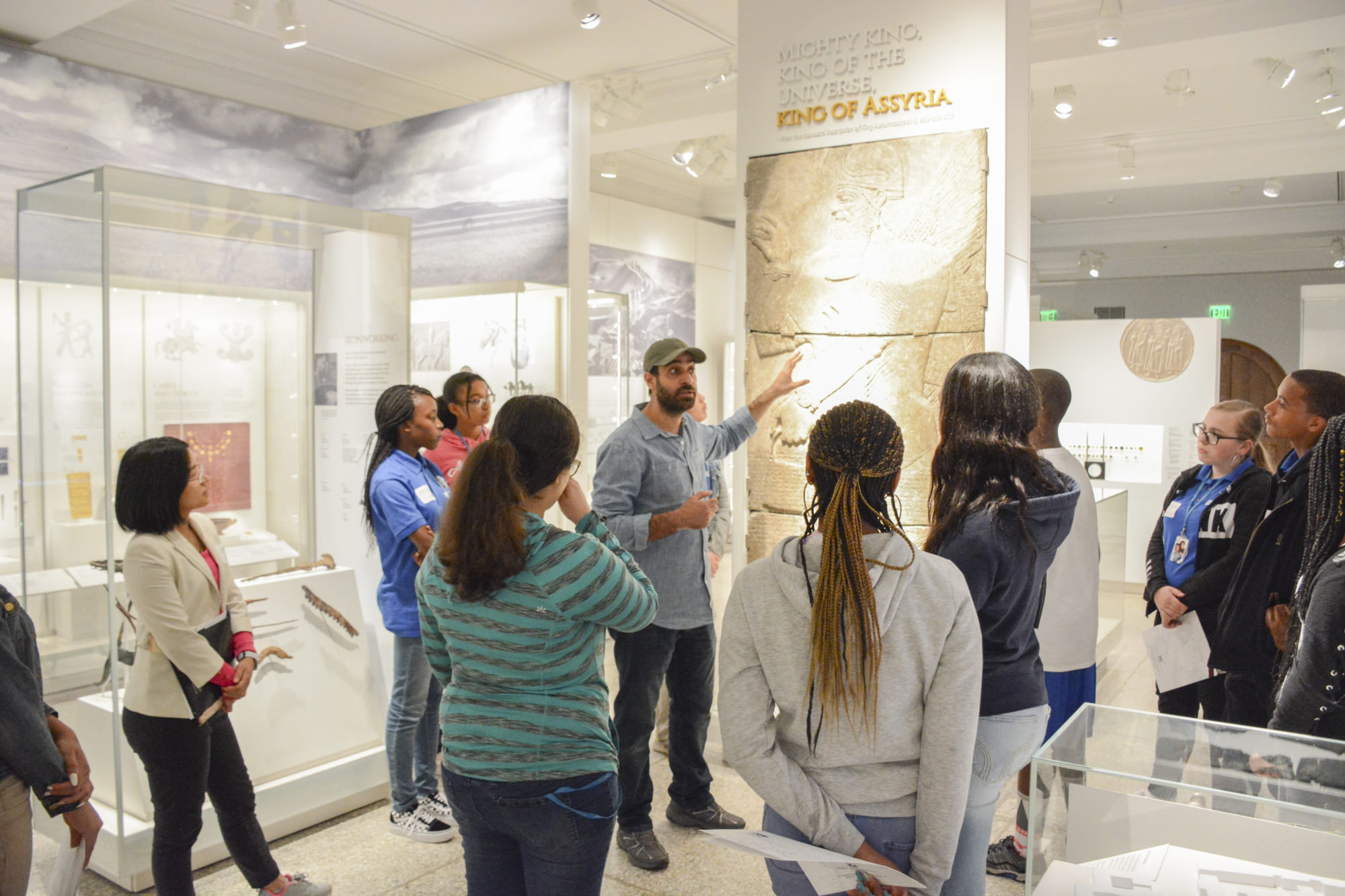 A gallery tour with a Global Guide speaking and gesticulating toward a graphic on display.