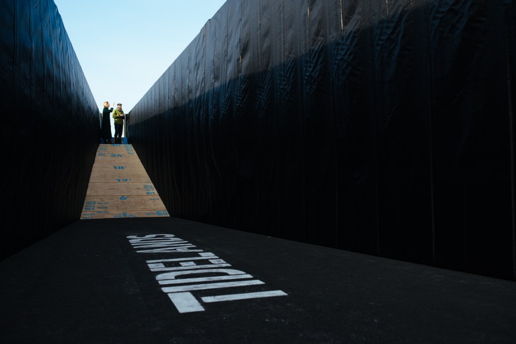 A ramp leads to an underground cavity where the word "Tidelands" is painted on the ground.