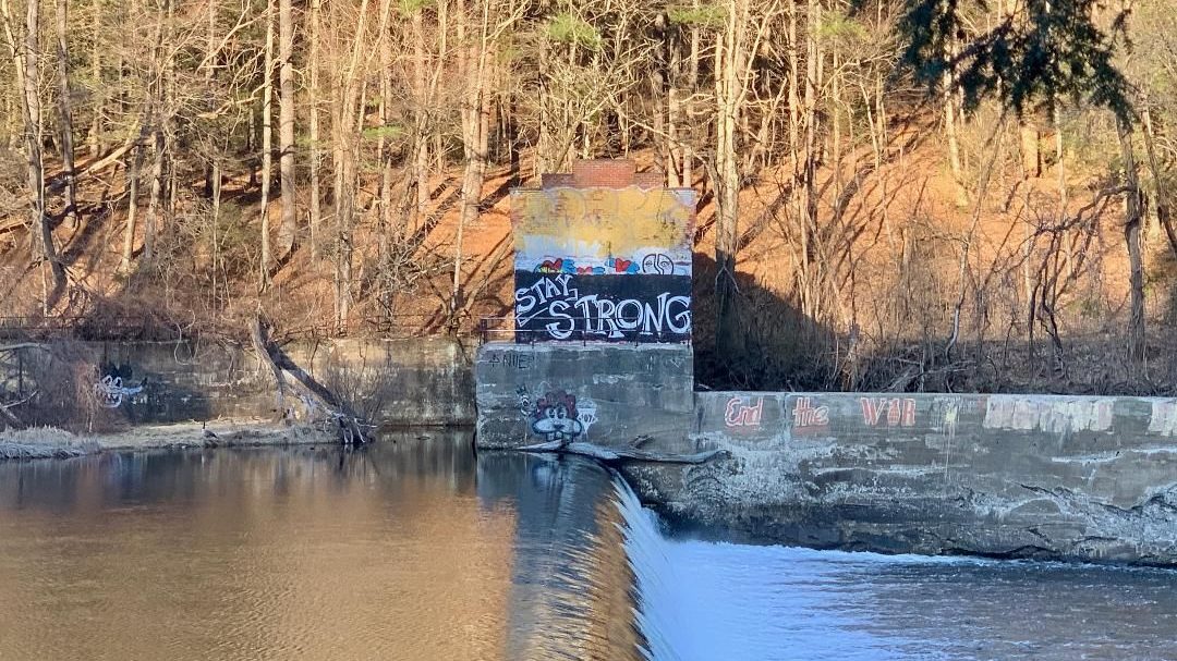Graffiti reading "Stay Strong" near a river