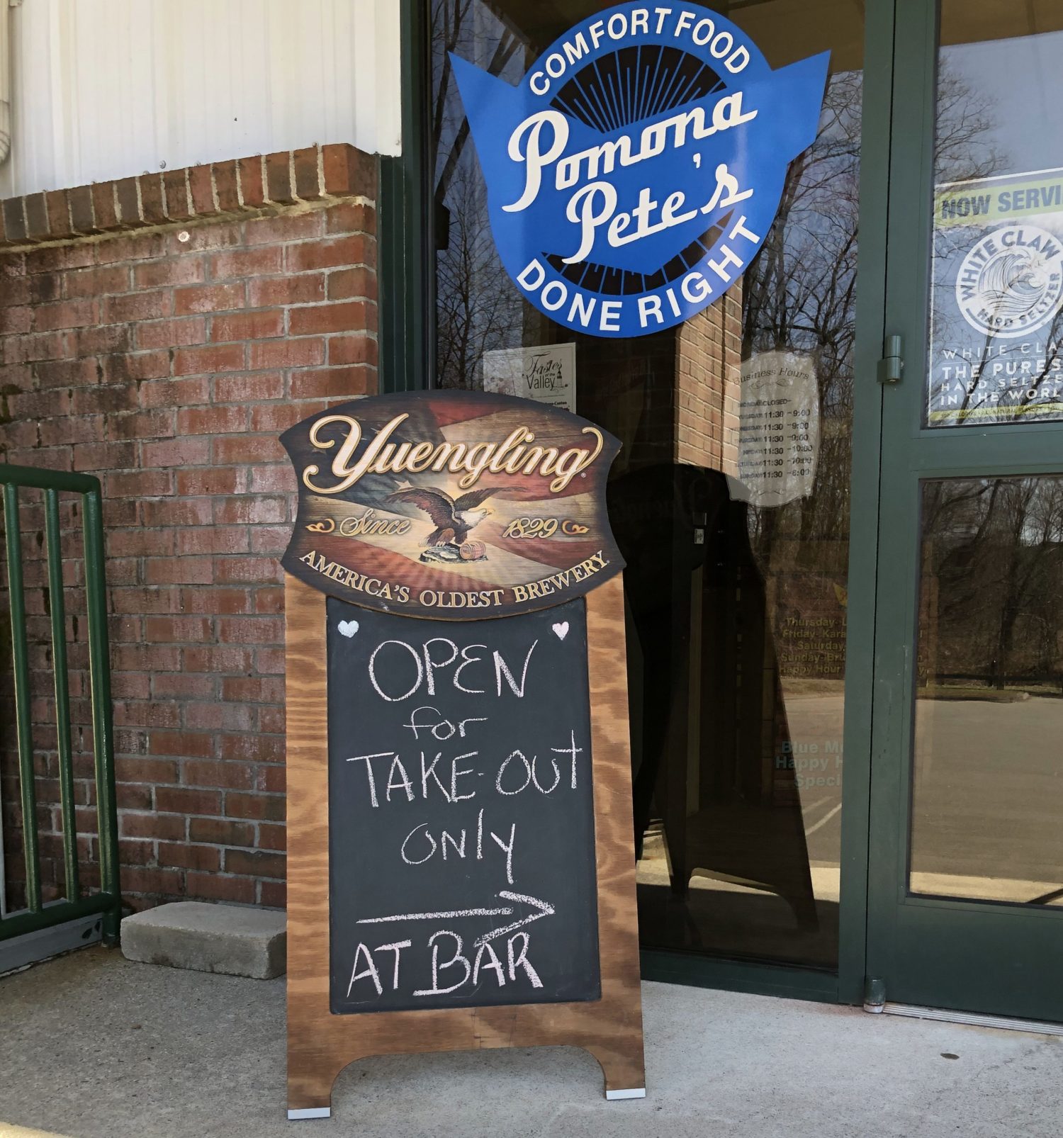 The exterior of a restaurant called "Pomona Pete's" with a sidewalk sign reading "Open for Take Out Only at Bar"