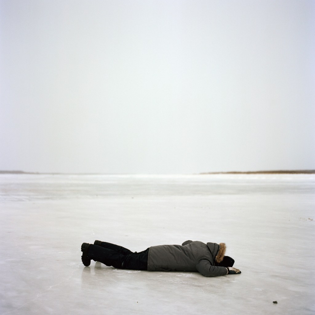 A person lying flat on a frozen river