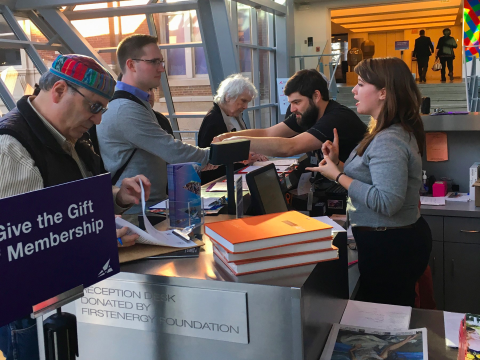 Staff receiving guests behind an admissions desk